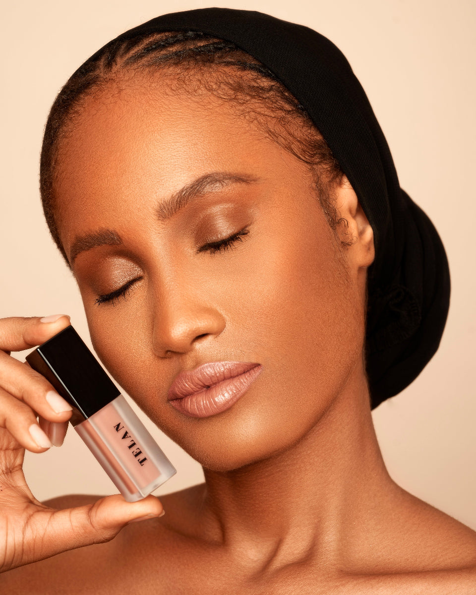 A model with closed eyes holding Telan Dofi Lip stain