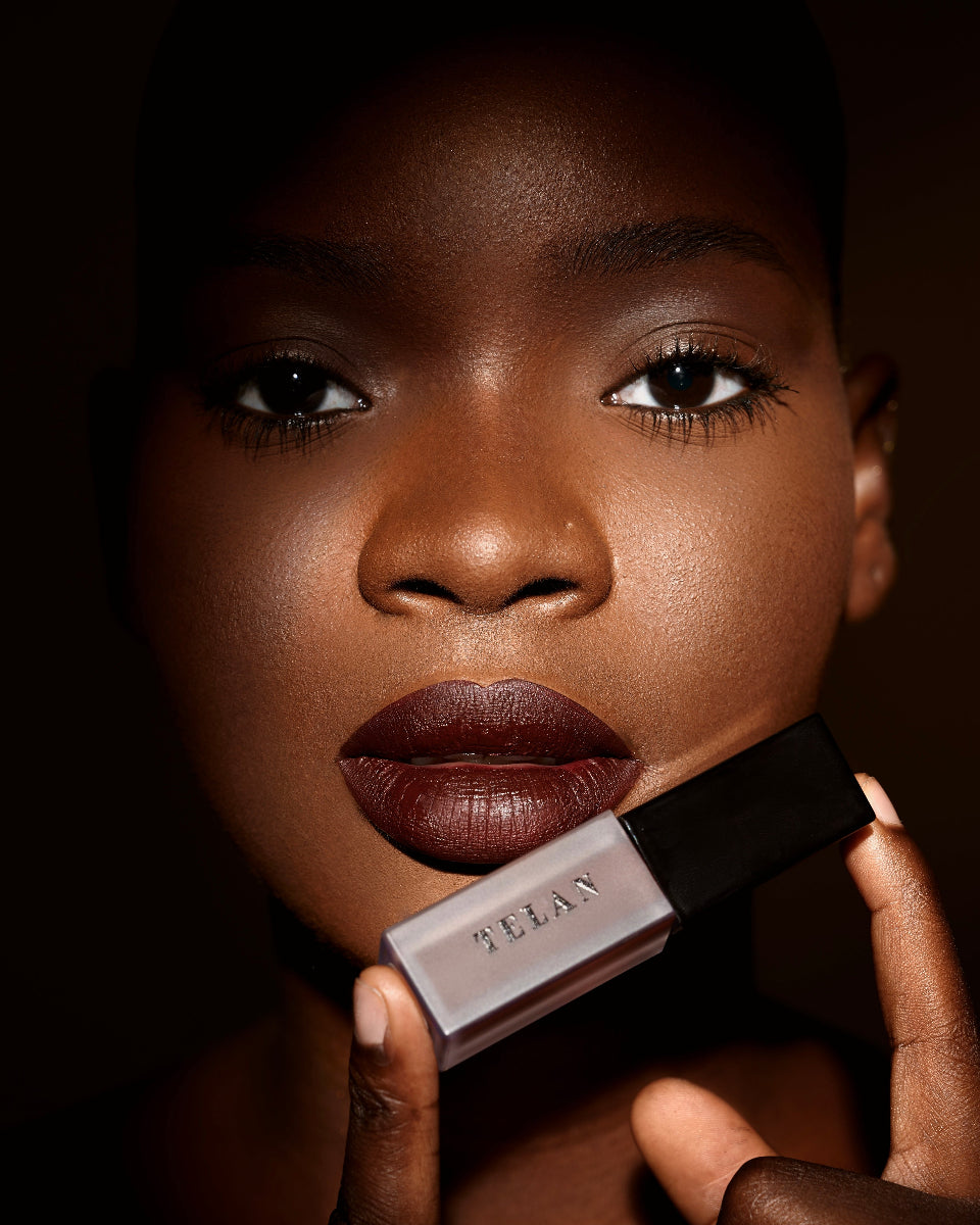 A model holding Telan Ojije Lip stain against a dark background